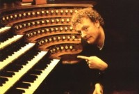 Howard pointing at the keyboard of an organ